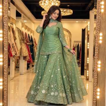 Alternate pose showing the sage green embroidered outfit and dupatta